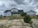Exterior of home surrounded by rocks and lush landscaping under a cloudy sky at 7186 Weaver Cir, Castle Rock, CO 80104
