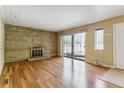 Inviting living area with beautiful floors, brick fireplace, and sliding doors for natural light at 1160 S Clinton St # 40, Denver, CO 80247