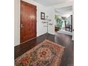 Elegant foyer with dark hardwood floors, a decorative rug, and a view into the dining area at 3391 Oak St, Wheat Ridge, CO 80033