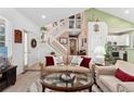 Bright living room with a staircase, sofa, glass table, and neutral color palette at 6819 S Webster St # E, Littleton, CO 80128