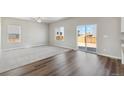 Bright living room features hardwood floors, a ceiling fan, and access to the backyard at 7303 Dolores Ave, Frederick, CO 80530