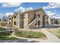 Attractive condo exterior features a mix of stone and stucco, complemented by lush landscaping at 4730 Copeland Cir # 203, Highlands Ranch, CO 80126