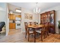 Dining area with chandelier, wood floors, and view of updated kitchen at 635 S Alton Way # 3B, Denver, CO 80247
