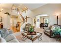 A spacious living room boasts soaring ceilings, a staircase, and seamless flow into the adjacent dining area at 11830 Snowshoe Dr, Parker, CO 80138