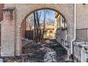 View through stone archway of backyard with stone path and small shed at 1965 Jasmine St, Denver, CO 80220