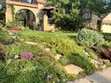 Beautifully landscaped yard with vibrant flowers, lush greenery, and inviting walkway at 1965 Jasmine St, Denver, CO 80220
