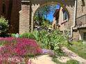 Picturesque view through brick archway of flower garden in front yard of home at 1965 Jasmine St, Denver, CO 80220