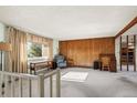 Spacious living room with wood paneled wall, large window, and views of the outside at 9430 Osceola St, Westminster, CO 80031