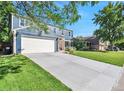 Lovely home featuring a spacious driveway, attached garage, and lush green lawn on a sunny day at 4643 S Vivian Ct, Morrison, CO 80465