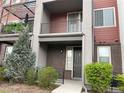 Modern townhome with private balcony, brick facade, and well-manicured landscaping at 4280 E Warren Ave # 2, Denver, CO 80222