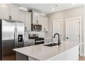 Well-equipped kitchen with stainless steel appliances, gray cabinets, quartz countertops, and modern fixtures at 17935 E 94Th Ave, Commerce City, CO 80022