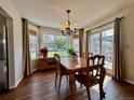 Bright dining area featuring hardwood floors, a window, and sliding glass doors leading to the backyard at 5432 S Cathay Way, Centennial, CO 80015