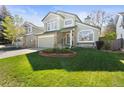 Charming two-story home with a well-manicured lawn, stone accents, and a two-car garage at 5432 S Cathay Way, Centennial, CO 80015