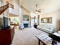 Spacious living room with vaulted ceilings, fireplace, large windows, and comfortable seating area at 5432 S Cathay Way, Centennial, CO 80015