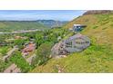 Spacious home on a hillside featuring an open rooftop deck with a fire pit, surrounded by lush greenery at 17313 W 43Rd Dr, Golden, CO 80403