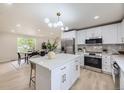 White kitchen with stainless steel appliances, granite countertops and eat-in dining area at 7325 Taft Ct, Arvada, CO 80005