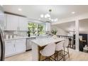 Modern kitchen featuring white cabinetry, an island with bar seating, and bright lighting at 7325 Taft Ct, Arvada, CO 80005
