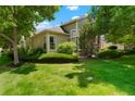 Well-maintained exterior with a manicured lawn, mature trees, and detailed landscaping around the home at 5155 W Quincy Ave # L101, Denver, CO 80236
