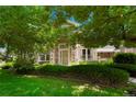 Charming front yard with lush greenery and mature trees framing the entrance at 5155 W Quincy Ave # L101, Denver, CO 80236