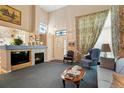 Inviting living room with a fireplace, high ceilings, and ample natural light, decorated with blue accents at 5155 W Quincy Ave # L101, Denver, CO 80236