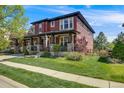 Beautiful two-story home with a welcoming front porch and lush green lawn at 13324 W 86Th Dr, Arvada, CO 80005