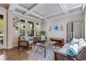 Cozy living room featuring hardwood floors, coffered ceiling, and ample natural light at 13324 W 86Th Dr, Arvada, CO 80005