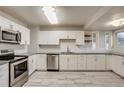 Contemporary kitchen boasts stainless steel appliances, white cabinets, and sleek countertop space at 8408 W 62Nd Pl, Arvada, CO 80004