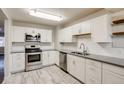 Modern kitchen features new stainless steel appliances, white cabinets, and light gray countertops at 8408 W 62Nd Pl, Arvada, CO 80004