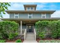 Charming home featuring a covered front porch, a well-manicured lawn, and classic architectural details at 2345 Akron St, Denver, CO 80238
