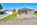 Charming house with a detached garage featuring a quilt-themed garage door and a well-kept lawn at 1775 Longbranch St, Strasburg, CO 80136