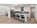 Modern kitchen with white cabinetry, quartz island with seating, and stainless-steel appliances at 11103 Cloud Shadow St, Littleton, CO 80125