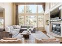 Spacious living room with fireplace, mantle, large sectional couch, and large windows at 5184 Pinyon Jay Rd, Parker, CO 80134