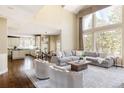 Bright living room featuring hardwood floors, neutral furniture, and expansive windows with natural light at 5184 Pinyon Jay Rd, Parker, CO 80134