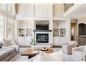 Comfortable living room with fireplace, built-in shelves, and large windows for natural light at 5184 Pinyon Jay Rd, Parker, CO 80134