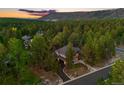 Stunning aerial view of the home nestled among lush trees and the surrounding scenic landscape at 7737 Taylor Cir, Larkspur, CO 80118