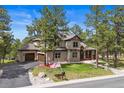 Beautiful two-story home with a three-car garage and a well-manicured lawn at 7737 Taylor Cir, Larkspur, CO 80118