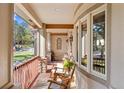 Inviting porch with wood flooring, rocking chairs, and stone accents, perfect for relaxation and enjoying the outdoors at 7737 Taylor Cir, Larkspur, CO 80118