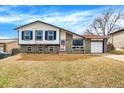 Charming split-level home with a brick and siding exterior, well-kept lawn and an attached garage at 1565 S Helena Cir, Aurora, CO 80017
