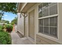Close-up of the front door and a window featuring neutral siding and well kept landscape at 1276 S Zeno Cir # A, Aurora, CO 80017