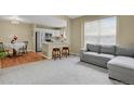 Open concept living space featuring plush seating, neutral tones, and an adjacent kitchen area at 1276 S Zeno Cir # A, Aurora, CO 80017