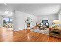 Cozy living room featuring a fireplace, hardwood floors, and a view into the adjacent dining room at 7250 W Vassar Ave, Lakewood, CO 80227