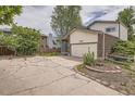 Driveway leading to a house with brick accents and a large garage at 7198 Eaton Ct, Arvada, CO 80003