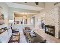 Open living room featuring a stone fireplace, large sofa, and view into the kitchen at 6410 Silver Mesa Dr # B, Highlands Ranch, CO 80130