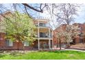 Apartment building exterior featuring multiple balconies with a lush green lawn at 1560 Milwaukee St # 240, Denver, CO 80206
