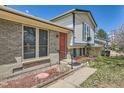 Close-up of a home's front entrance, featuring a brick facade and a bright red door at 2155 S Lewiston St, Aurora, CO 80013