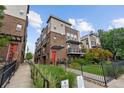 Modern townhouse with brick and siding, featuring a red front door, balcony, and landscaped front yard with walkway at 1325 Jackson St, Denver, CO 80206