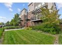Townhouses with brick and siding, featuring a red front door, balcony, and landscaped front yard at 1325 Jackson St, Denver, CO 80206