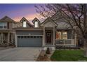 Charming two-story home with a covered front porch, grey siding, a well-kept lawn and an attached garage at 1811 Hogan Ct, Castle Rock, CO 80109
