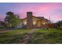 Charming home featuring a brick chimney, well-manicured lawn, and a welcoming front walkway at 5420 E 61St Way, Commerce City, CO 80022