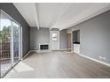 Bright living room with gray walls, fireplace, and a sliding glass door opening to a balcony at 9995 E Harvard Ave # 166, Denver, CO 80231